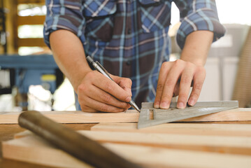 Hands of person doing diy project at home. Man measuring wood to doing cabinet craftworks as a hobby.