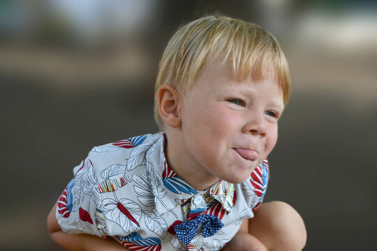 Blond boy 4 years old playing on a children playground and has fun. High quality photo