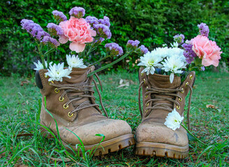 boots and flowers on green grass