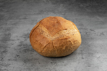 Loaf of fresh bread on gray concrete background