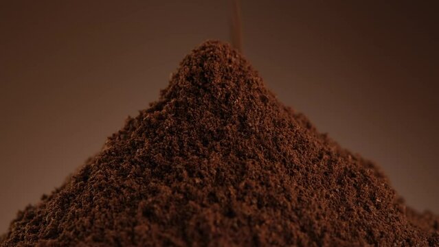 Ground black coffee on brown background