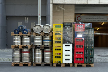 Stack of a beverage delivery in Berlin with beverage crates and metal barrels at the back of a...