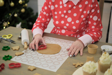 perfect housewife in her perfect kitchen. a woman in a red dress prepares cookies.