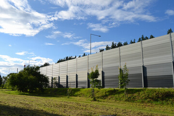 A noise barrier (also called a soundwall, noise wall, sound berm, sound barrier, or acoustical...