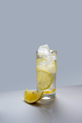 water with lemon and ice cubes in a glass