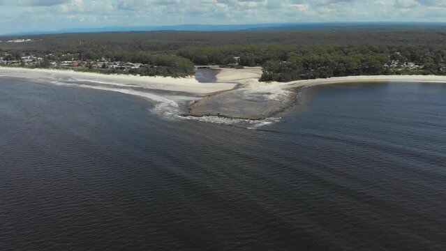 Drone video of Moona Moona Creek and Huskisson beach area after recent flooding with brown dirty water flowing into the bay
