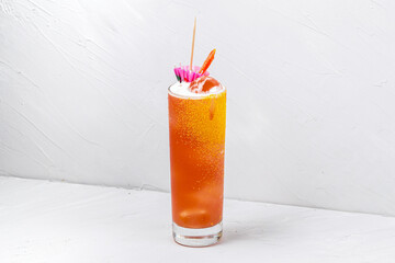 Glass of refreshing sweet orange alcoholic cocktail on white background