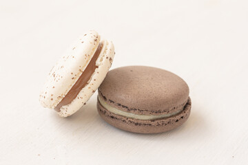 White and brown creamy macarons on white background. Freshness concept.