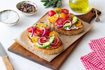 Bruschetta with avocado, tomatoes, onions and white cheese. Vegetarian food. Sandwich. Italian food.