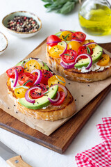 Bruschetta with avocado, tomatoes, onions and white cheese. Vegetarian food. Sandwich. Italian food.