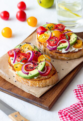 Bruschetta with avocado, tomatoes, onions and white cheese. Vegetarian food. Sandwich. Italian food.