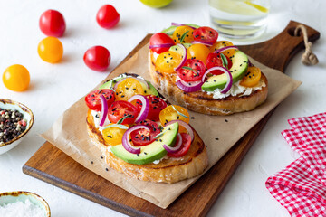 Bruschetta with avocado, tomatoes, onions and white cheese. Vegetarian food. Sandwich. Italian food.