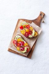 Bruschetta with avocado, tomatoes, onions and white cheese. Vegetarian food. Sandwich. Italian food.