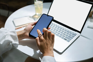 Close up virw, young asian woman holding smart phone use to searching information or shopping online and using computer laptop working or meeting online with her business group