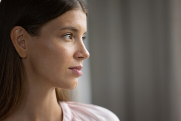 Profile view beautiful face serious young 30s woman. Close up thoughtful female staring into distance looks pensive, deep in thoughts. Daydream, eyesight care, laser vision correction services concept