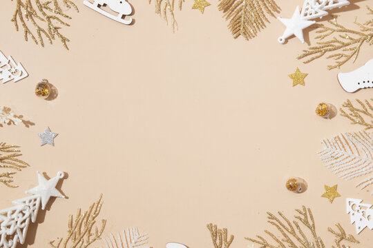 Festive Christmas and New Year backround with golden white holiday decoration on pastel beige with copy space. Top view. Merry Christmas monochrome concept