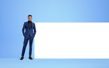 African businessman standing near mockup banner on blue background