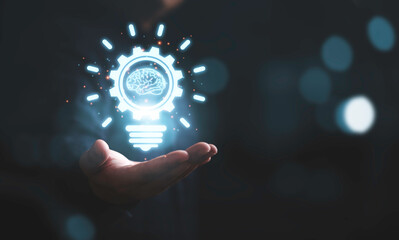 Businessman holding glowing drawing lightbulb with virtual brain and connection line, creative thinking ideas and innovation concept.