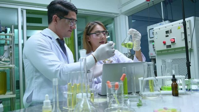 Scientists and assistants are in the oil and cannabis seed extractor room. The extracted cannabis oil is being tested and examined.