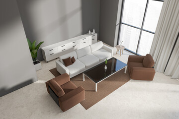 Top view of grey lounge zone interior with couch and coffee table, panoramic window
