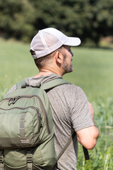 Man with green backpack exploring nature, vacation concept.