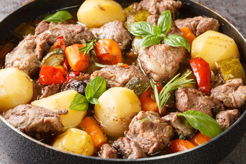 Tasty Peka Meat and vegetables in the traditional Balkan, Serbian, Bosnian dish close-up on the table. horizontal