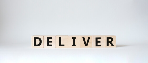 Deliver symbol. Concept word Deliver on wooden cubes. Beautiful white background. Business and Deliver concept. Copy space.