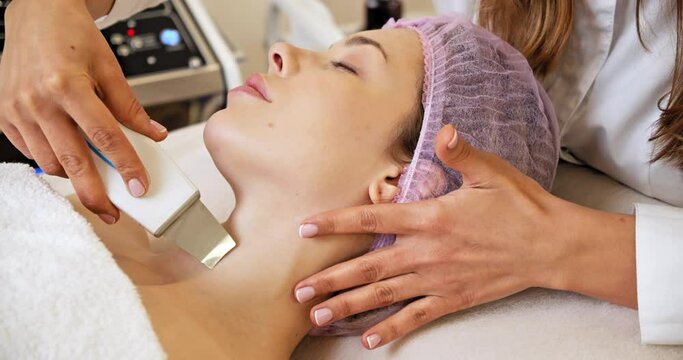 Beautiful woman receiving facial microcurrent treatment at spa salon. Beautician using electrical impulses for facial procedures. Woman in spa salon. Woman in a spa salon on cosmetic procedures.