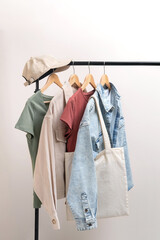 Basic women`s clothes and eco bag on white background. Woman collection of clothes on a rack....