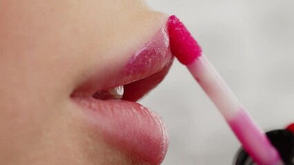 Closeup shot stylist applies lipstick  to the lips of the female model. Woman making make up applying lipstick on a lip. Professional makeup. Tutorial makeup master class. Making mua. Slow motion.
