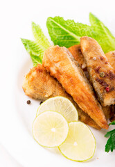 appetizing fish fillet with vegetables and herbs on a white plate