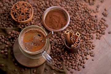 Hot black coffee and coffee beans on the old wooden table