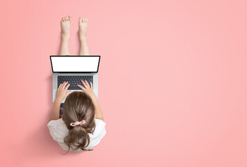 Little girl works on a laptop computer. View from above. Isolated screen for mockup, website or game promotion. Copy space beside on red background