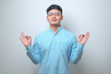 Naklejka premium Handsome young man smiling positive doing ok sign with hand and fingers. successful expression.