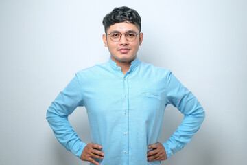 Young asian man wearing casual shirt and glasses confident keeping hands on hips