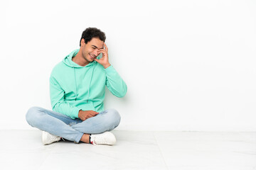 Caucasian handsome man sitting on the floor laughing