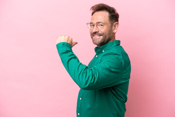 Middle age caucasian man isolated on pink background proud and self-satisfied