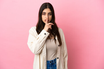 Young caucasian woman isolated on pink background showing a sign of silence gesture putting finger in mouth