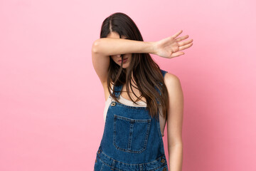 Young caucasian woman isolated on pink background covering eyes by hands