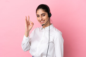 Young telemarketer over isolated background showing ok sign with fingers