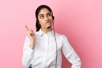 Young telemarketer over isolated background with fingers crossing and wishing the best