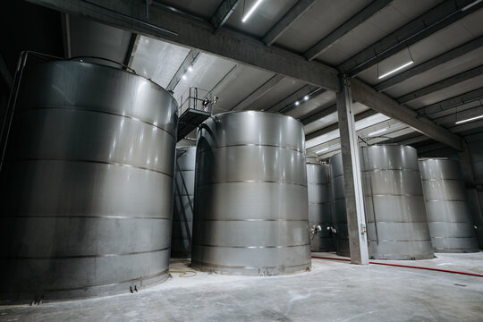 Huge warehouse for wine storing with giant stainless steel tanks. Industrial production of alcohol drink theme.