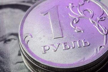 a coin with a face value of 1 ruble lies on a banknote of the American dollar. close-up