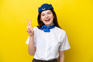 Airplane stewardess Russian woman isolated on yellow background smiling and showing victory sign