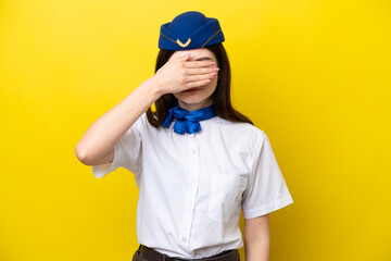 Airplane stewardess Russian woman isolated on yellow background covering eyes by hands. Do not want to see something
