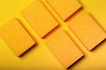 Yellow sponges for washing dishes background. Trendy yellow background, household cleaning sponge. Housework concept