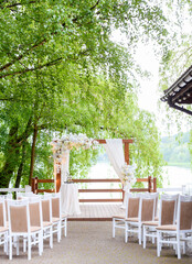 Beautiful summer wedding arch for ceremonies in the forest against the background of the lake