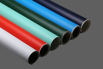 Row of various multicolored vinyl films or plotter cutting film rolls on grey background wide...