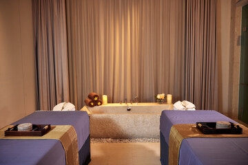 Stylish spa room interior with two massage tables and a bathtub. Spa skin and body care. Beauty treatment. Cosmetology.