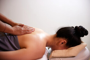 Young woman receiving a back massage in luxury spa center. Aromatherapy, beauty, wellness and relaxation treatment